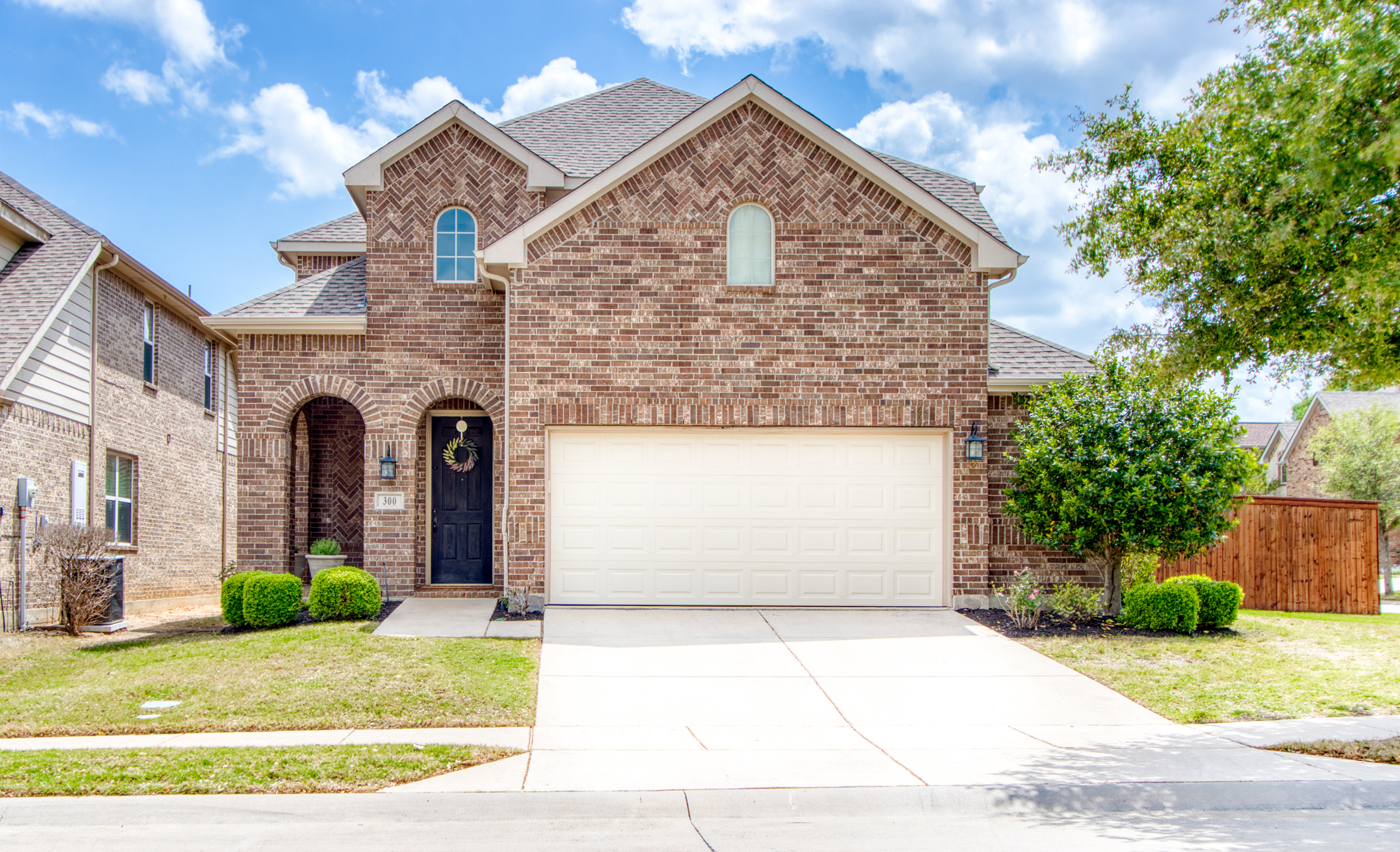 A beautiful and luxurious corner lot home in Lantana's vibrant community, featuring elegant French doors, a spacious open-concept living room and kitchen, large windows providing ample natural light, and an oversized garage with extra storage space. The home is surrounded by lush greenery, with a gorgeous yard and side yard perfect for outdoor activities.